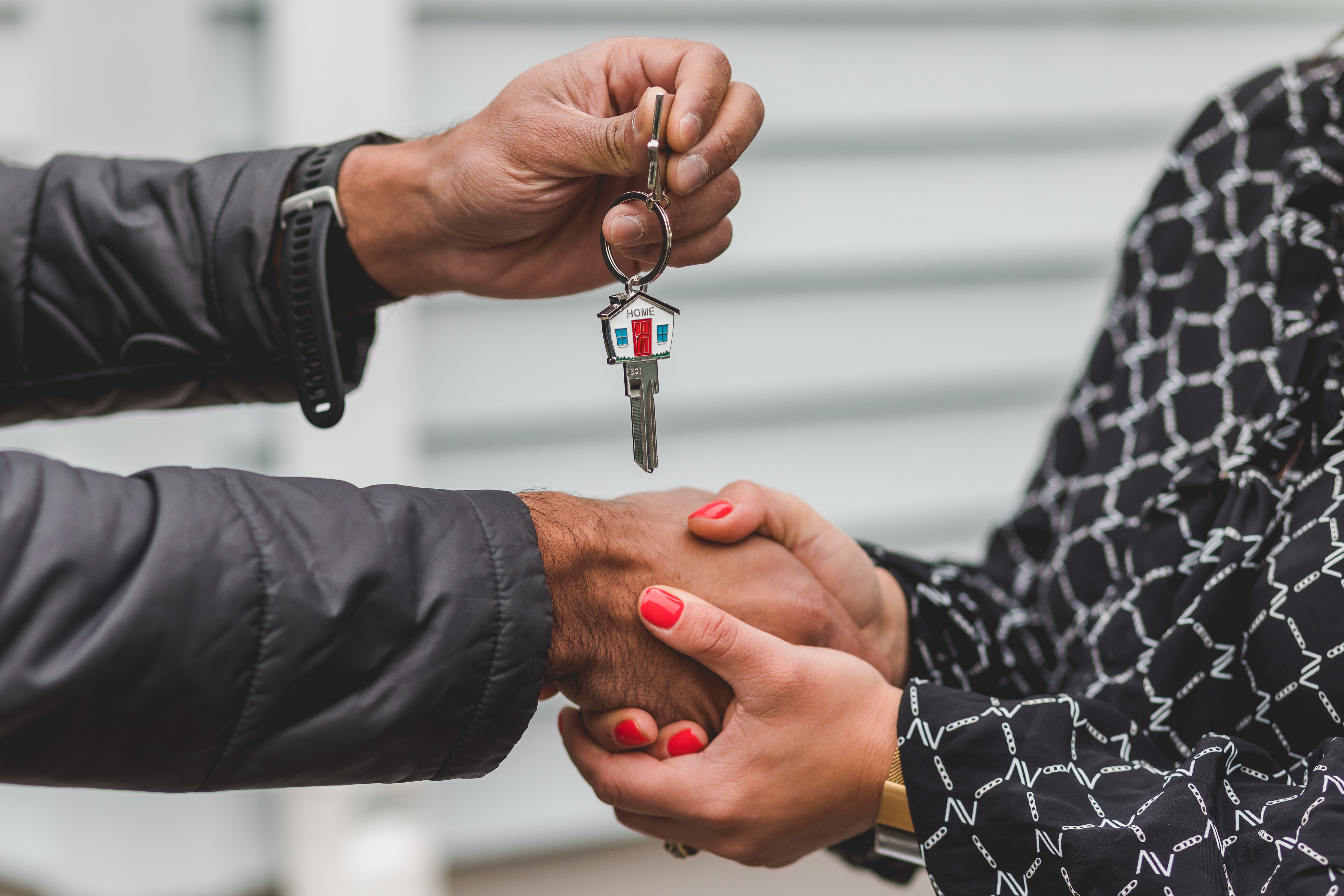 Un homme donne la clef d'un logement à une femme