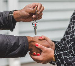 Un homme donne la clef d'un logement à une femme
